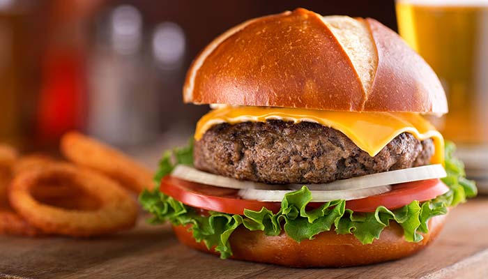 Ledgens Bar & Grill restaurant in Midland Texas cheeseburger topped with American cheese, lettuce, tomato, onions and a side of onion rings