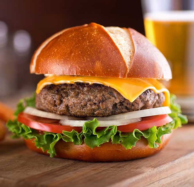 Ledgens Bar & Grill restaurant in Midland Texas cheeseburger topped with American cheese, lettuce, tomato, onions and a side of onion rings